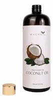 Uma garrafa de vidro âmbar de 100ml de Óleo de Coco Fracionado Puro da marca MAGAOIL, com o rótulo mostrando um coco partido e folhas. A tampa dourada metálica está removida e colocada ao lado, tudo contra um fundo branco puro.